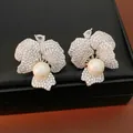 Elegant silver floral earrings featuring pave cubic zirconia and large central white pearls - Silver