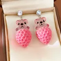 Détail de boucles d'oreilles pendantes ours fraise en résine avec clous en zircon. - Rose