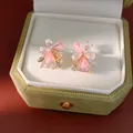 Primo piano di orecchini a lobo a fiore in resina rosa con zirconi su base quadrata. - Oro-Rosa