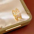 Gros plan d'une bague ouverte double couche en plaqué or 18k sertie de zircons - Or