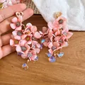Makro-Detail von rosa Stoffblumen-Ohrringen mit schillernden Herz-Kristall-Anhängern - Silber-Ohrstecker - Rosa
