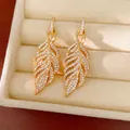 Elegante goldfarbene Ohrringe in Blattform, besetzt mit funkelnden Zirkonia - Hohlblatt-Stil / Gold