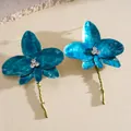 Close-up of dainty blue enameled flower earrings with rhinestone centers and long stems. - Stud Earrings (HE33141) / Light Blue