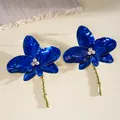 Detailed view of blue enamel orchid flower earrings with sparkling rhinestone centers and gold stems - Stud Earrings (HE33141) / Dark Blue