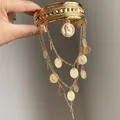 Gros plan détaillé d'un luxueux bracelet de bras en métal doré avec d'élégantes pièces pendantes - Or
