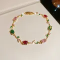 Detailed view of a gold-tone vine bracelet set with colorful oval gemstones - Colorful Vine / Gold