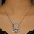 Close-up of artistic silver amphora pendant featuring floral relief and scroll textures - Arrangable Flower Frame Necklace / Silver