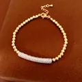 Detailed view of elegant gold beaded bracelet with a zircon-inlaid silver curved bar. - Silver