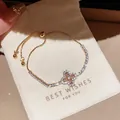 Détail d'un bracelet vintage avec trèfle en zircon rose sur un petit pochon de cadeau blanc - Trèfle de Cœur Rose (3#) / Or-Rose (3#)
