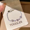 Détail d'un élégant bracelet floral en zircon rose sur une pochette cadeau TOGGLER - Style Chaîne Tennis Floral (19#) / Argent-Rose (19#)