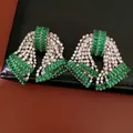 Primo piano dettagliato di orecchini a lobo vintage a fiocco con cristalli verdi e chiari - Argento/Verde