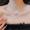 Close-up of a zircon bow pendant pearl necklace worn as a sweet princess style collar - Style 27
