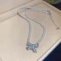 Detalle de colgante de lazo con circonitas en collar de perlas blancas - Plateado