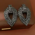 Primo piano di orecchini neri a forma di foglia con strass su una scatola di gioielli. - Stile Foglia a Goccia d'Acqua (HE32666) / Canna di fucile