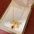 Gros plan d'un collier vintage doré avec pendentifs en perle et œil de tigre - Collier ras-du-cou / Brun doré