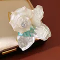 Primer plano exquisito de una pulsera de concha hecha a mano con diamantes de imitación y piedras - Dorado Plateado Beige