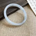 Macro di un bracciale in calcedonio grigio traslucido su uno sfondo rustico elegante - Ciano (Stile 13)