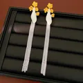 Vue détaillée de boucles d'oreilles vintage à fleurs en émail et longues chaînes d'argent - Jaune Et Blanc