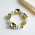 Detailansicht der Retro-Perlenkette mit zerknitterten Goldperlen und Perlenakzent - Armband / Gold-Weiß