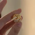 Detailansicht eines mehrlagigen goldenen Ohrmanschetten mit funkelnden Zirkoniasteinen - Clip-on (Einzeln) / Gold