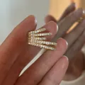 Detailaufnahme einer mehrlagigen goldenen Ohrmanschette mit funkelnden Zirkonia. - Clip-on (Einzeln) / Silber