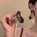 Close-up detail of elegant purple butterfly earrings with gold tassels and stones - Butterfly Tassel Pendant Style / 1 Pair Pack / Purple/Gold