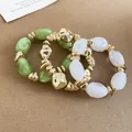 Close-up detail of three-piece irregular acrylic and gold-toned elastic bracelets. - 50# Bracelet / Three-Piece Set / Gold-Green-Transparent