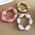 Macro view of the irregular pink and white acrylic beads on elastic bracelet set with gold accents. - 46# Bracelet / Three-Piece Set / Gold-Pink-Transparent