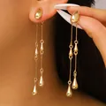 Elegant gold drop tassel earrings featuring a sleek oval stud and cascading metallic charms - 06kc Gold Dz-004