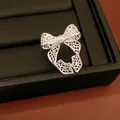 Detailed macro view of a silver hollow bow open ring on black leather jewelry tray - Hollow Bow Style / Silver