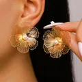 Detailed close-up of oversized gold flower stud earrings with elegant faux pearl accent. - Stud Earrings (y26071311) / Gold