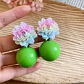 Macro detail view of resin flower earrings with large vibrant green spheres in Dopamine style - Green