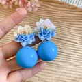 Close-up of vibrant blue resin flower earrings with matching spherical beads - Blue
