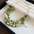 Nahaufnahme einer mehrlagigen grünen Muschelperlenkette mit Silberkette im Schmucktablett. - Mehrlagige grüne Muschel-Halskette mit großer silberner Gliederkette / Silber-Grün