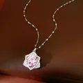 Close-up of a sparkling star pendant necklace with a large pink round zircon center stone. - Silver-Pink