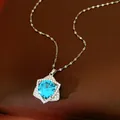 Detailed macro view of an exquisite star-shaped necklace with a sparkling blue zircon. - Silver-Blue