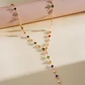 Gros plan d'un collier doré avec des cristaux colorés et des breloques en cœur - Collier-Or-Multicolore-Rond (Long)
