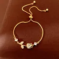 Detailed shot of an adjustable gold tulip bracelet featuring sparkling zircon stones. - Tulip (HB5670) / Gold-White