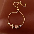 Detailed macro view of gold tulip flower bracelet with pink zircon and adjustable pull chain - Tulip (HB5670) / Gold-Pink