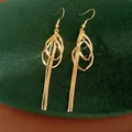 Close-up of gold waterdrop geometric hollow earrings with long tassel chains on green velvet - Waterdrop Tassel Style (HE32655) / Gold