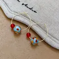 Primo piano dettagliato di orecchini a cerchio in resina con perle rosse e pois colorati. - Cerchio Rotondo / Punti rossi e blu