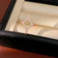Detail view of 18k gold plated four-point star ring with sparkling zirconia in a gift box - Gold