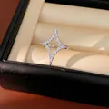Close-up detail of a sparkling zircon starburst open ring inside a luxury jewelry gift box - Silver