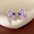 Dettaglio ravvicinato di eleganti orecchini a fiore in resina viola con pietre rosa - Viola