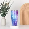 Detail of 30oz galaxy patterned stainless steel tumbler with spill-proof lid on a pedestal - 30oz