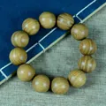 Grünes Sandelholz-Armband mit zwölf natürlichen Holzperlen auf einem Vintage-Buch - Einzelschleifen-Stil / 20mm x 12 Stk