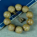 Grünes Sandelholz Armband mit Holzanhängern auf einem blauen antiken Buch - Kürbis Stil / 25mm x 10 Stk