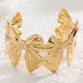 Macro shot of gold-plated wide cuff bracelet with interlocking bow design and metallic finish - 10 Kc Gold 2508