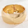 Nahaufnahme des goldenen breiten Armreifs mit Spiegelglanz und Federgelenk-Detail - 04 Kc Gold 5443