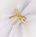 Polished golden bow napkin ring made of metal for elegant Christmas table decor - Bow